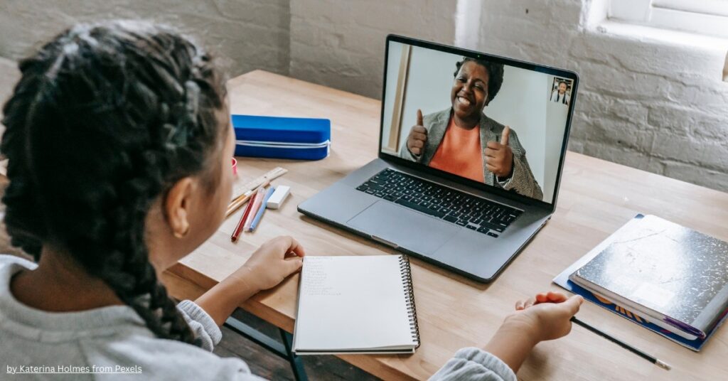 Student attending an online class, writing notes while talking to a teacher on video call – illustrating how can students make money through online tutoring.